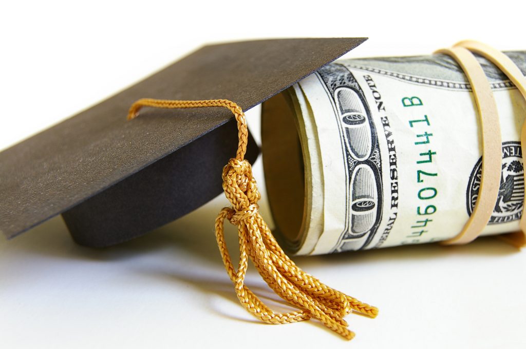 graduation cap and cash roll, closeup